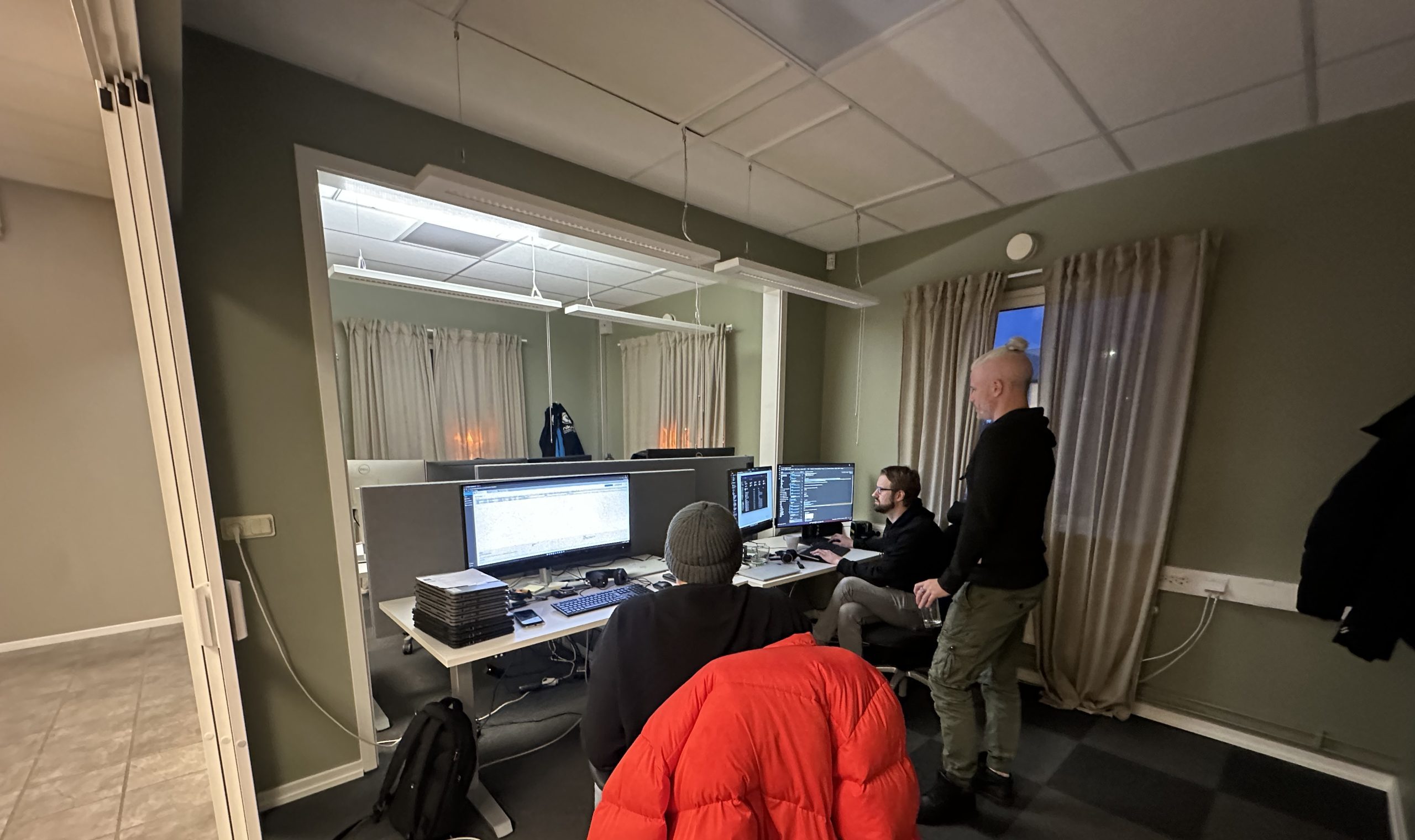 Tre IT-tekniker från Unikom sitter och arbetar.